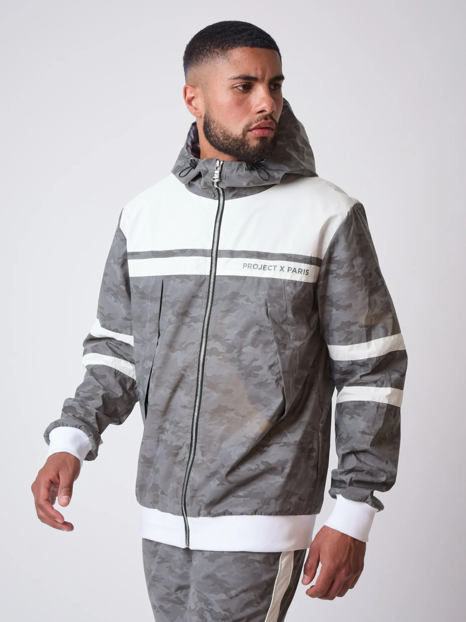 Chaqueta bimaterial reflectante con capucha y estampado de camuflaje 