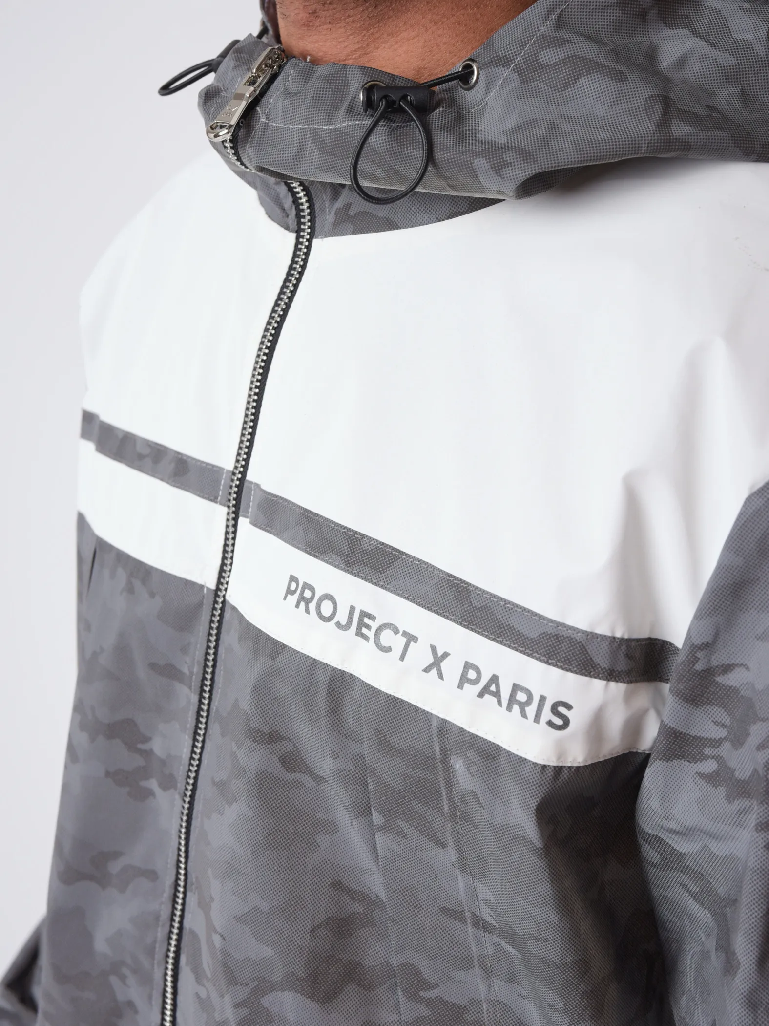 Chaqueta bimaterial reflectante con capucha y estampado de camuflaje 